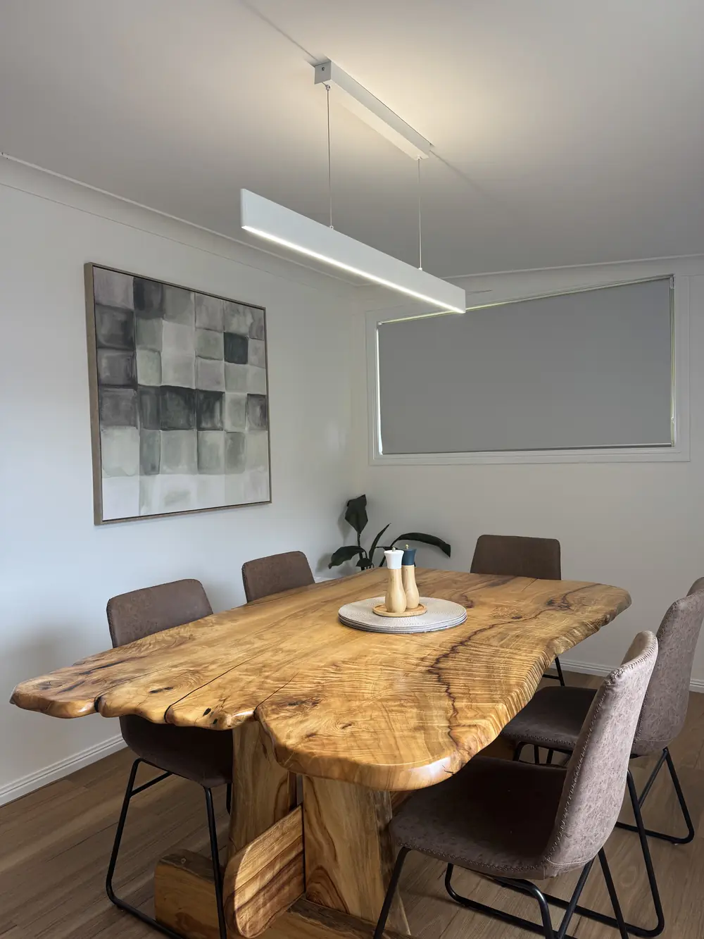 Pendant light above a timber dining table in a finished home interior