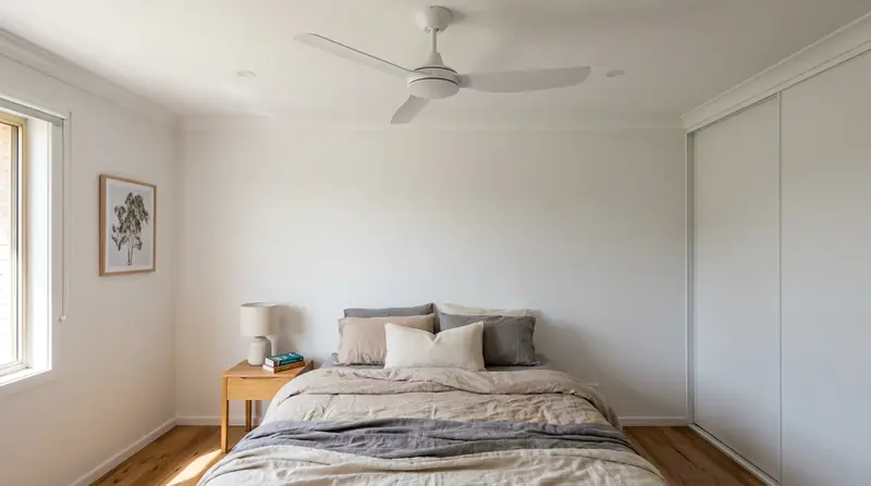 White ceiling fan installed above a bedroom