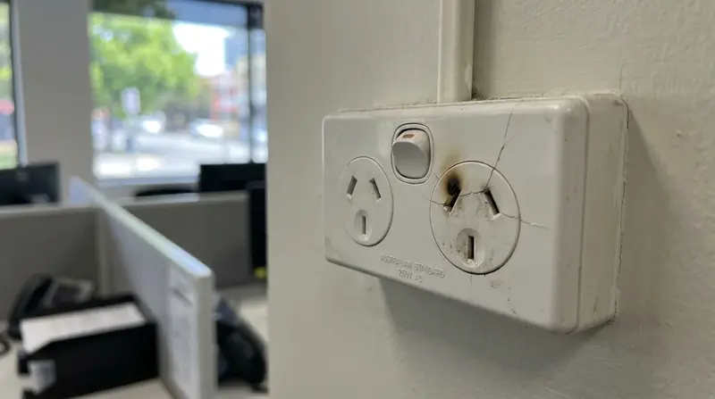 Burnt electrical power outlet with heat damage in a commercial office